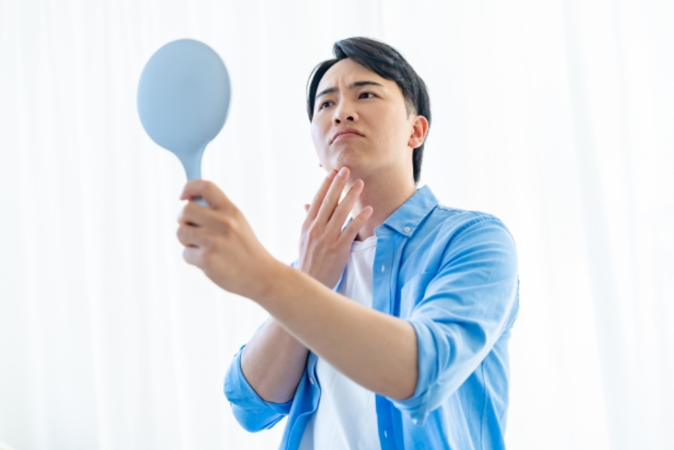 鏡を見る男性